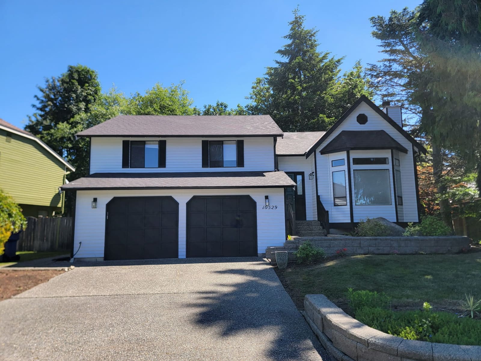 Seamless gutter replacement on a white and black two-story home.