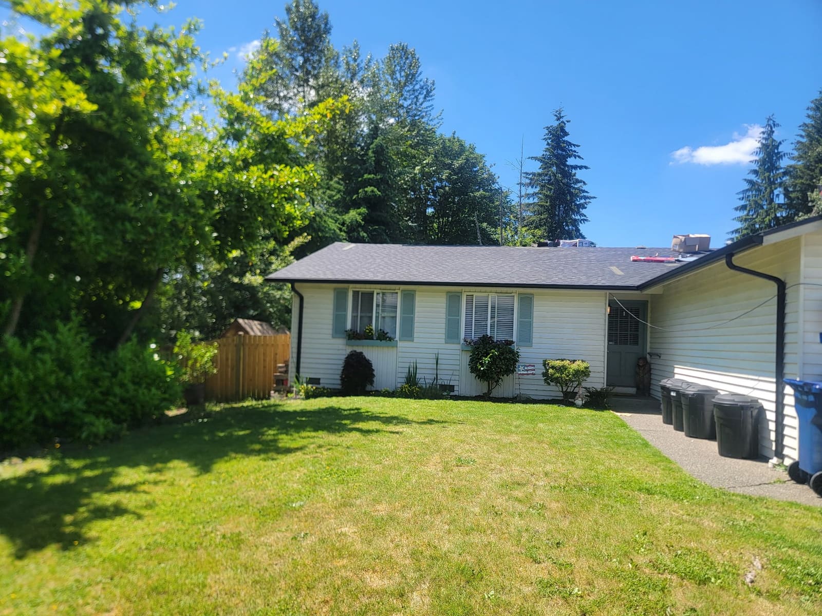 Seamless gutter replacement on a yellow ranch-style home with mature landscaping.